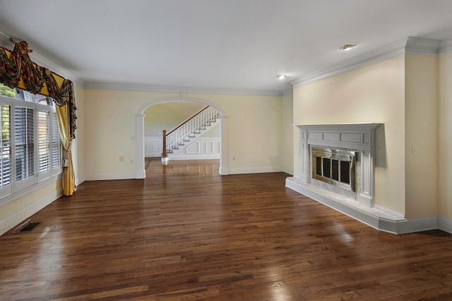 unfurnished living room with a premium fireplace, dark wood-type flooring, and crown molding