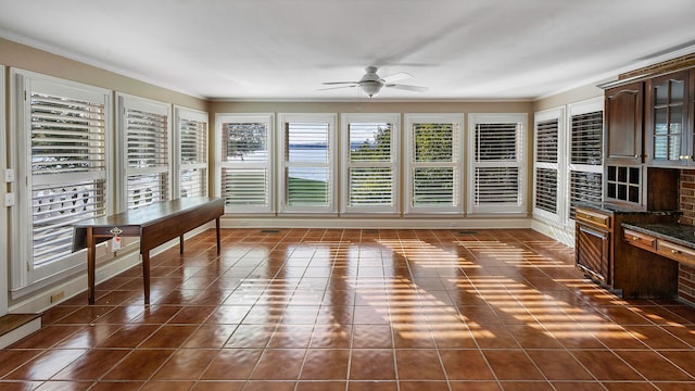 unfurnished sunroom with ceiling fan