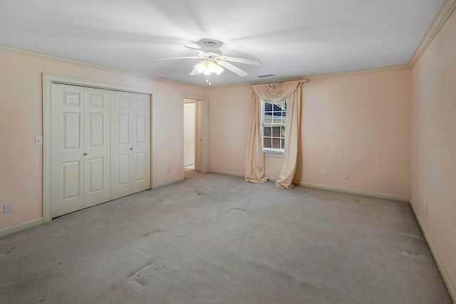 unfurnished bedroom featuring ornamental molding, ceiling fan, light colored carpet, and a closet