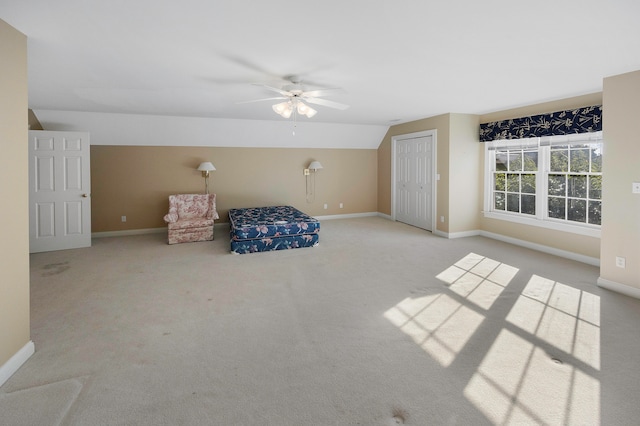 unfurnished bedroom featuring lofted ceiling, ceiling fan, light colored carpet, and a closet