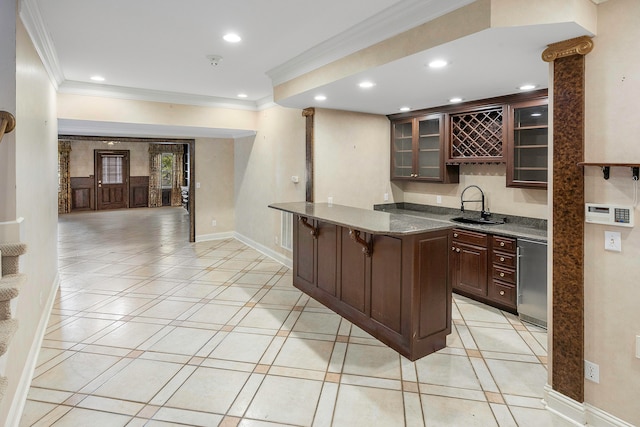 kitchen with sink, a breakfast bar area, dark brown cabinetry, crown molding, and light tile patterned floors