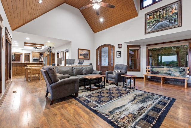 living room with ceiling fan, wood-type flooring, wood ceiling, and high vaulted ceiling