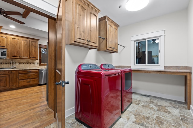 laundry room featuring ceiling fan, cabinets, light hardwood / wood-style floors, and washing machine and clothes dryer