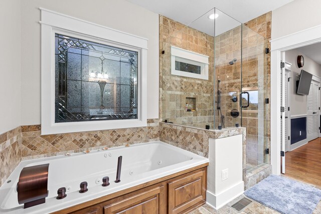 bathroom with shower with separate bathtub and hardwood / wood-style floors