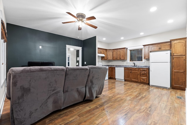 kitchen featuring white appliances, sink, ceiling fan, and hardwood / wood-style flooring