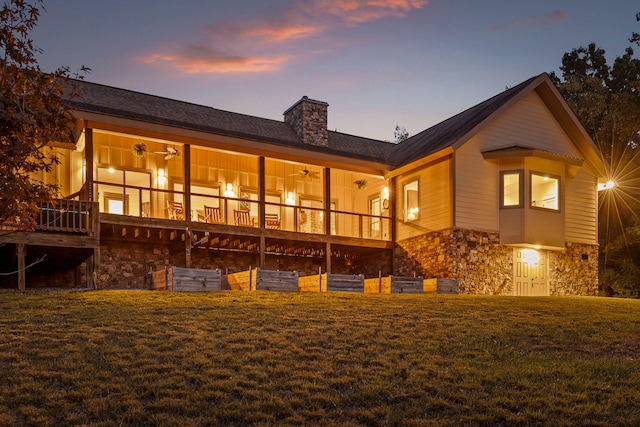 back house at dusk featuring a yard