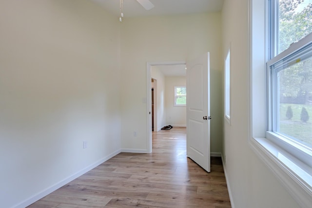 corridor featuring baseboards and light wood-type flooring