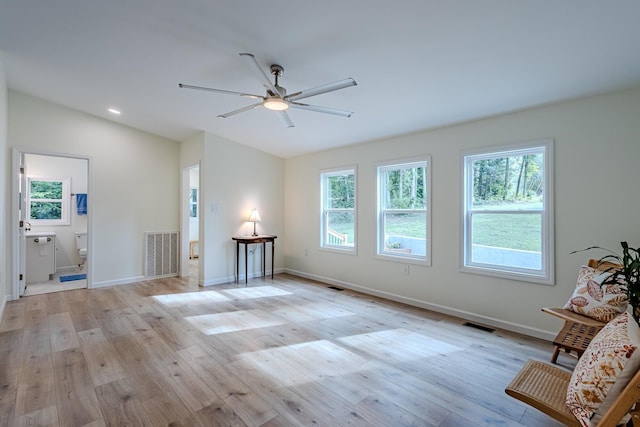 unfurnished living room with lofted ceiling, ceiling fan, visible vents, and light wood-style floors
