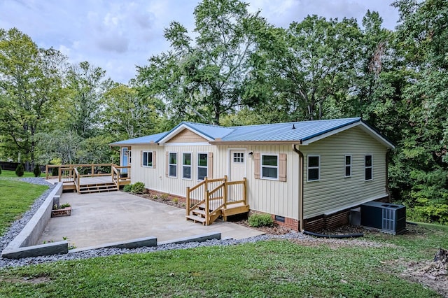 rear view of house with a deck, a patio, central AC unit, crawl space, and a yard