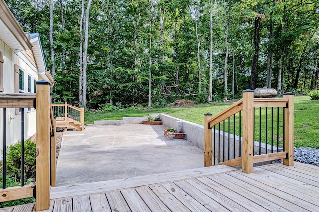 wooden terrace featuring a patio and a lawn