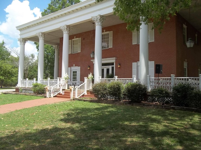 view of front of property with covered porch and a front yard