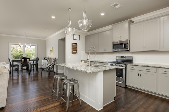 kitchen with appliances with stainless steel finishes, sink, pendant lighting, and dark hardwood / wood-style flooring