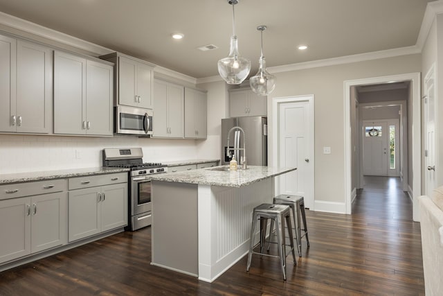 kitchen featuring dark hardwood / wood-style floors, a kitchen island with sink, stainless steel appliances, and gray cabinetry