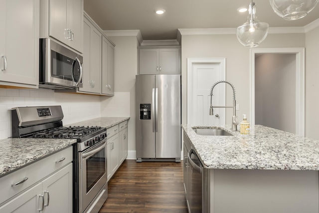 kitchen featuring appliances with stainless steel finishes, light stone countertops, a kitchen island with sink, dark wood-type flooring, and sink