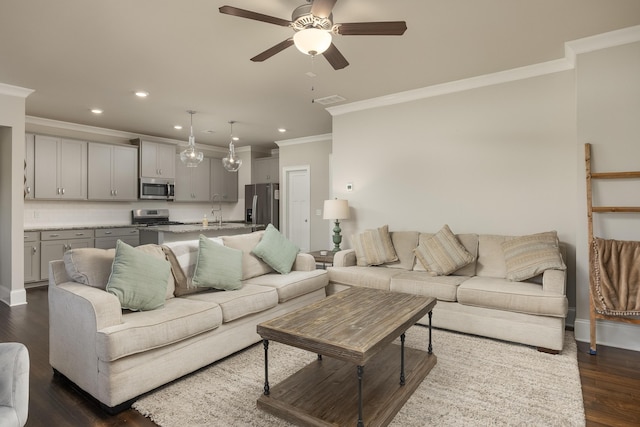 living room with ornamental molding, dark wood-type flooring, and ceiling fan