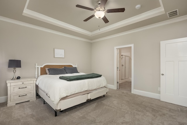 carpeted bedroom with ensuite bathroom, ornamental molding, ceiling fan, and a raised ceiling