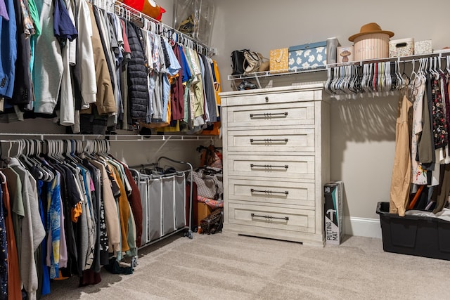 walk in closet with light colored carpet