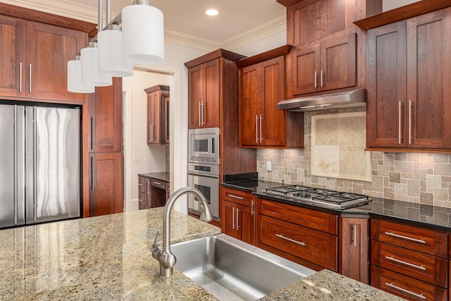 kitchen featuring dark stone countertops, stainless steel appliances, sink, decorative light fixtures, and tasteful backsplash