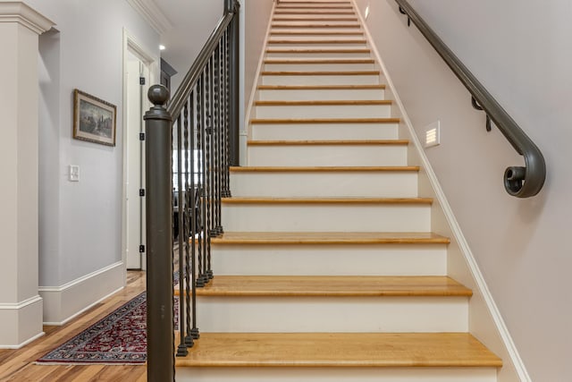 staircase featuring hardwood / wood-style flooring and ornamental molding