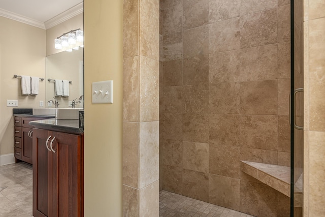 bathroom featuring a tile shower, ornamental molding, and vanity