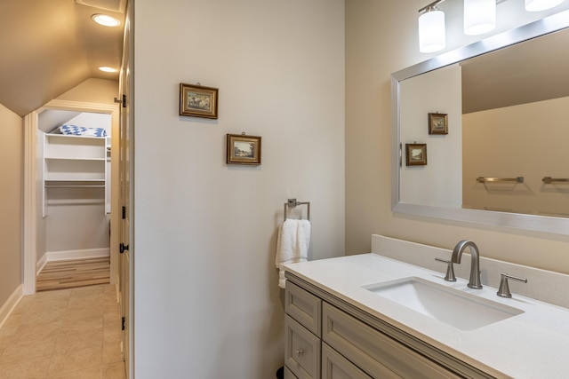 bathroom with lofted ceiling and vanity