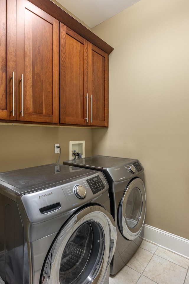 laundry room with cabinets, independent washer and dryer, and light tile patterned floors