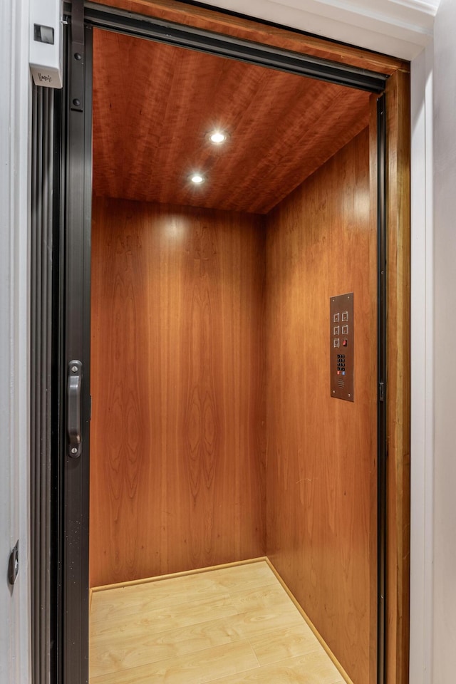 interior details featuring elevator and wooden walls