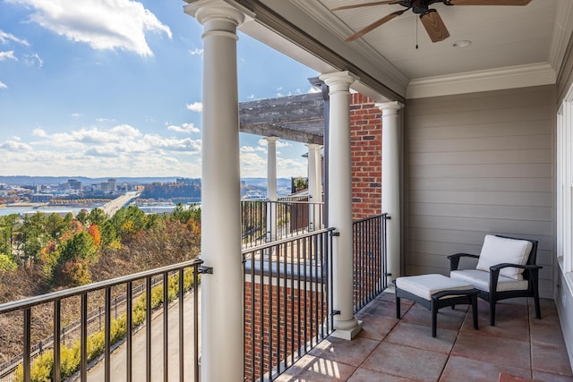 balcony with ceiling fan and a water view