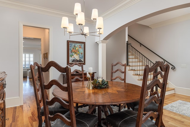 dining space featuring wood-type flooring, a chandelier, and crown molding