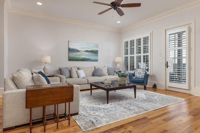 living room with ornamental molding, ceiling fan, and light hardwood / wood-style floors