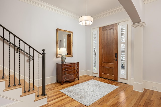 entryway featuring ornate columns, ornamental molding, a healthy amount of sunlight, and light hardwood / wood-style flooring