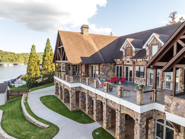 rear view of house featuring a water view and a patio area