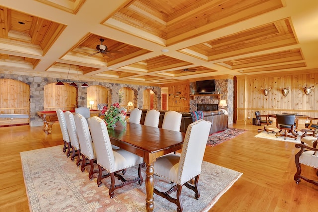 dining area featuring wood ceiling, ceiling fan, and a fireplace