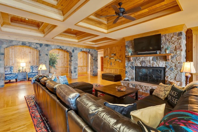 living room with coffered ceiling, hardwood / wood-style flooring, a fireplace, and ornamental molding