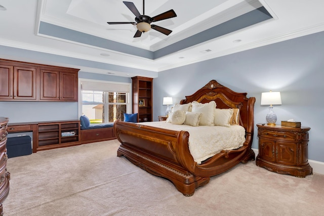 bedroom with ornamental molding, light colored carpet, a raised ceiling, and ceiling fan