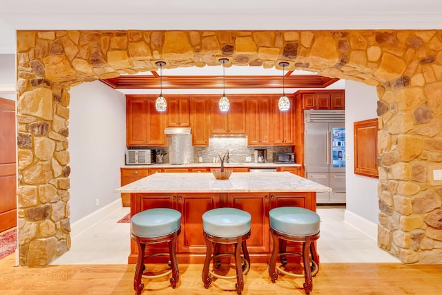 kitchen featuring ornamental molding, a center island, decorative backsplash, and decorative light fixtures