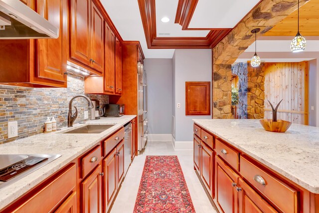 kitchen featuring tasteful backsplash, dishwasher, sink, hanging light fixtures, and light stone countertops