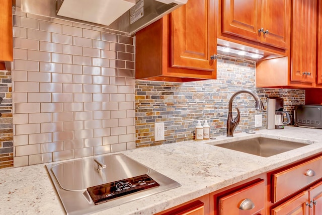 kitchen with light stone countertops, sink, and decorative backsplash