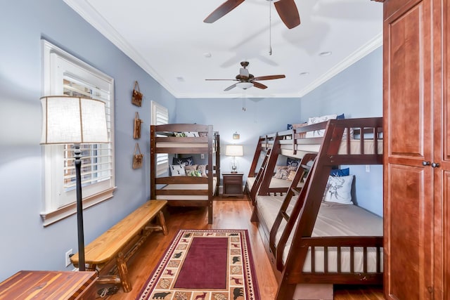 bedroom with multiple windows, wood-type flooring, and ornamental molding