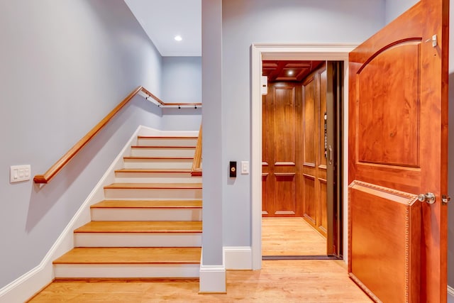 stairway with wood-type flooring and elevator