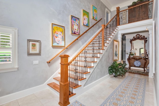 staircase with ornamental molding, tile patterned floors, and a high ceiling