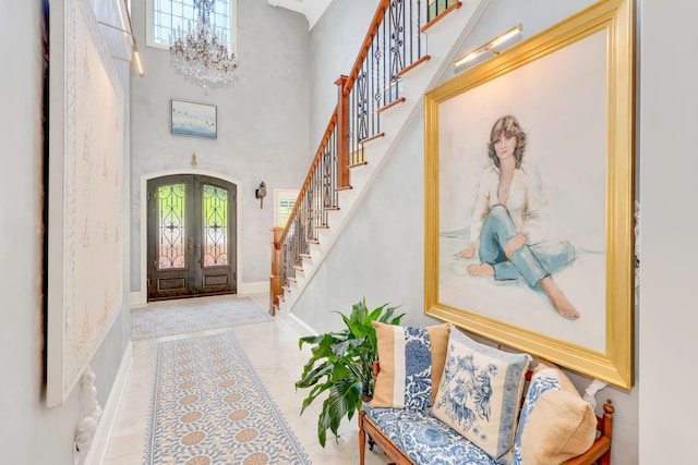 entrance foyer with french doors, a chandelier, and a high ceiling