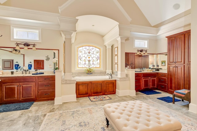 bathroom featuring ornate columns, a tub, and plenty of natural light