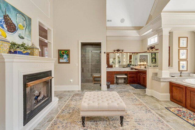 bathroom with decorative columns, plus walk in shower, a towering ceiling, and vanity