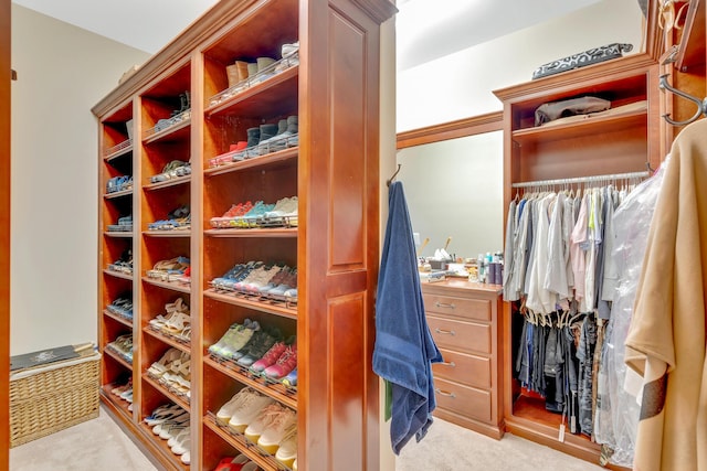 walk in closet featuring light carpet