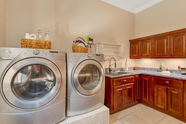 clothes washing area featuring sink, crown molding, washing machine and dryer, cabinets, and light tile patterned flooring