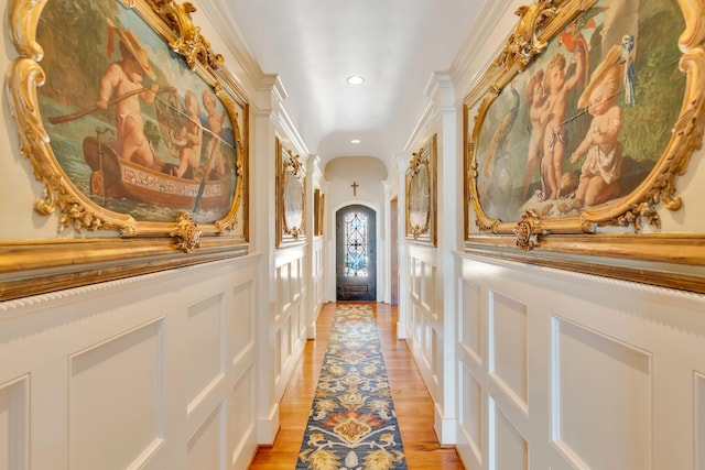 hall featuring crown molding and light hardwood / wood-style floors