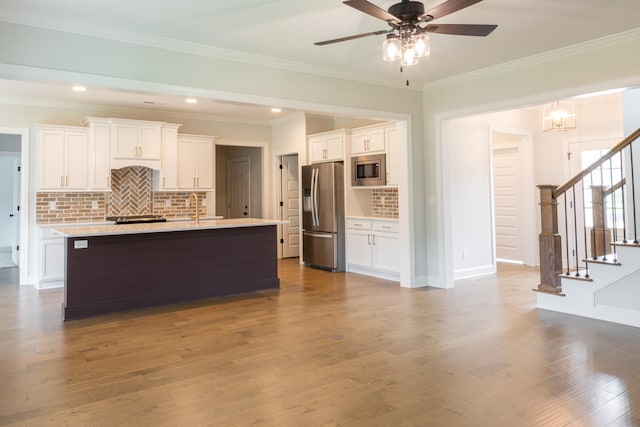 kitchen featuring hardwood / wood-style floors, appliances with stainless steel finishes, and white cabinetry