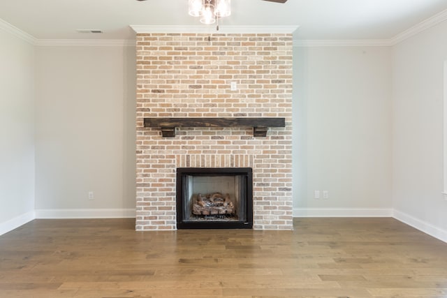 unfurnished living room with ornamental molding, wood-type flooring, a fireplace, and ceiling fan