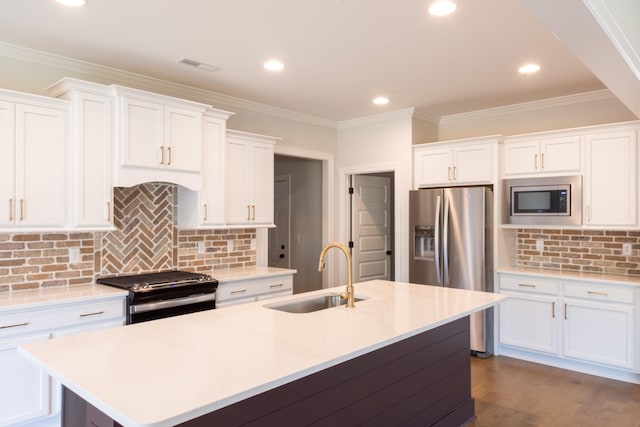 kitchen with dark wood-type flooring, a center island with sink, sink, white cabinets, and appliances with stainless steel finishes